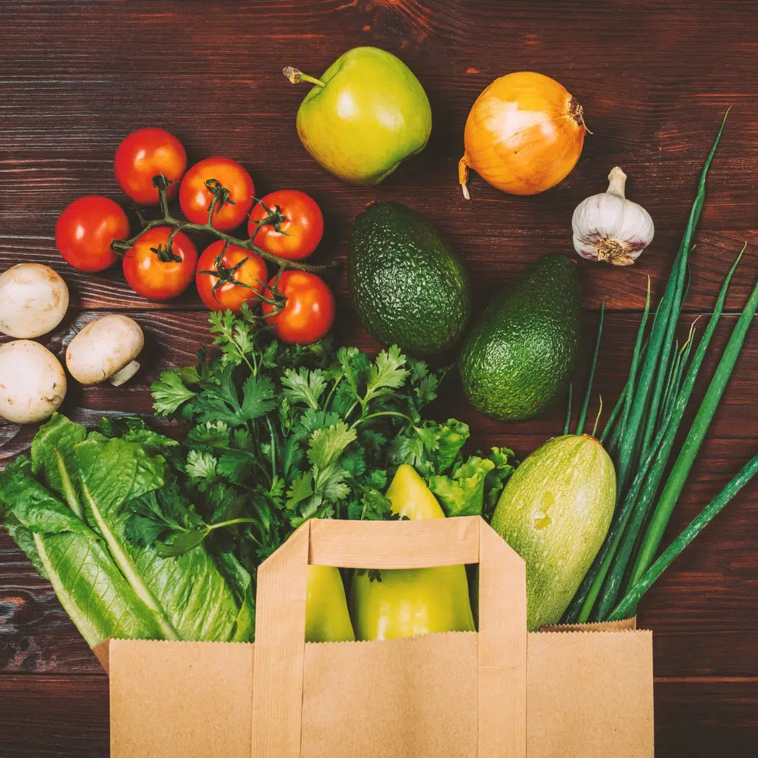 Organic produce: assorted vegetables and fruits in a reusable bag, emphasizing pesticide-free choices for hormone balance.