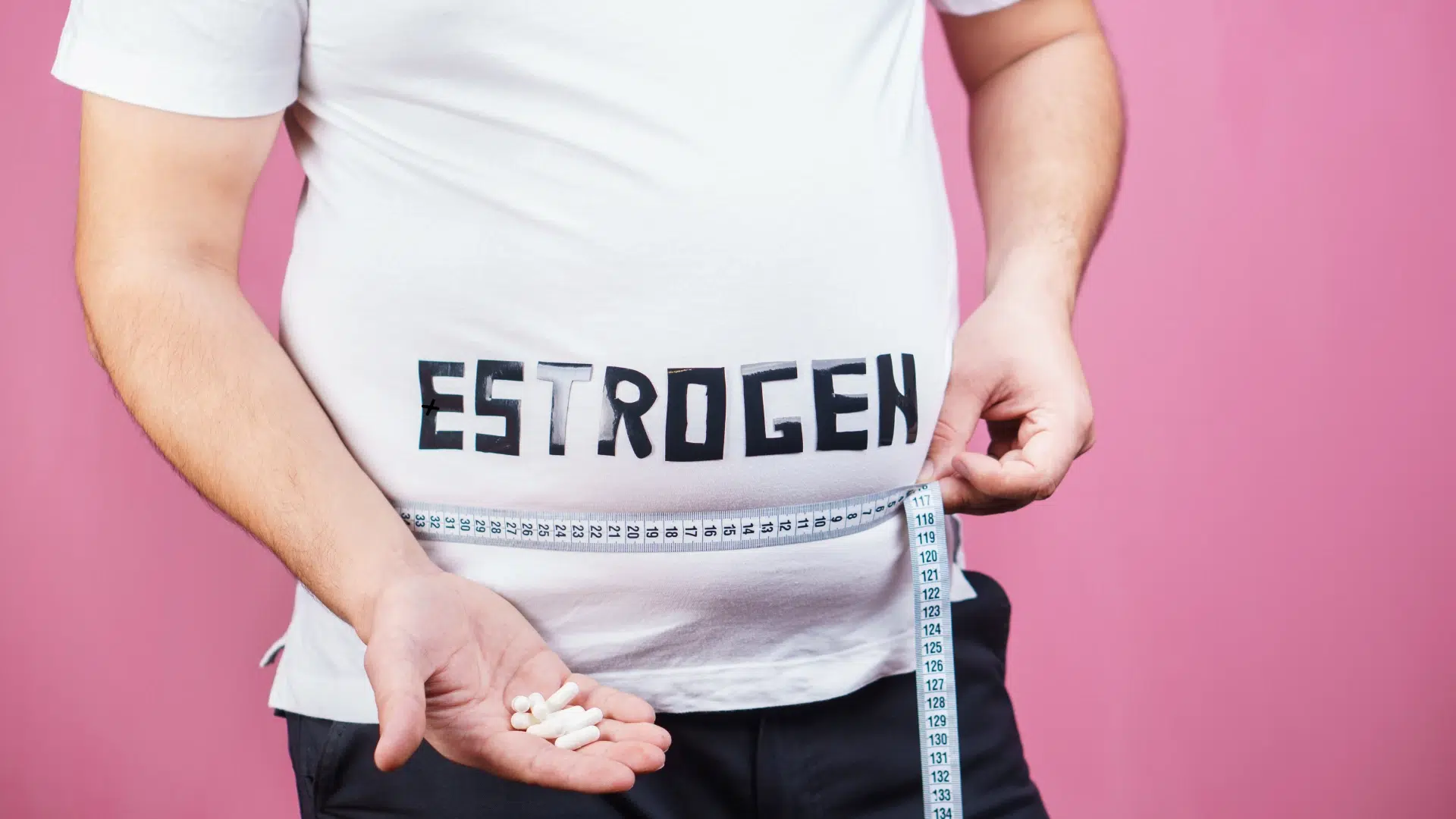 Person in Estrogen t-shirt measures waistline while holding pills, illustrating estrogen dominance.